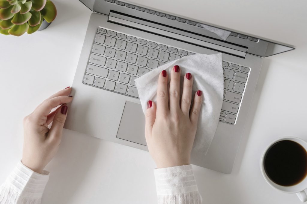 Cleaning laptop with antibacterial wipe