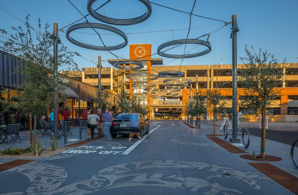 Gilbert Heritage District plaza at sunset with people and cars