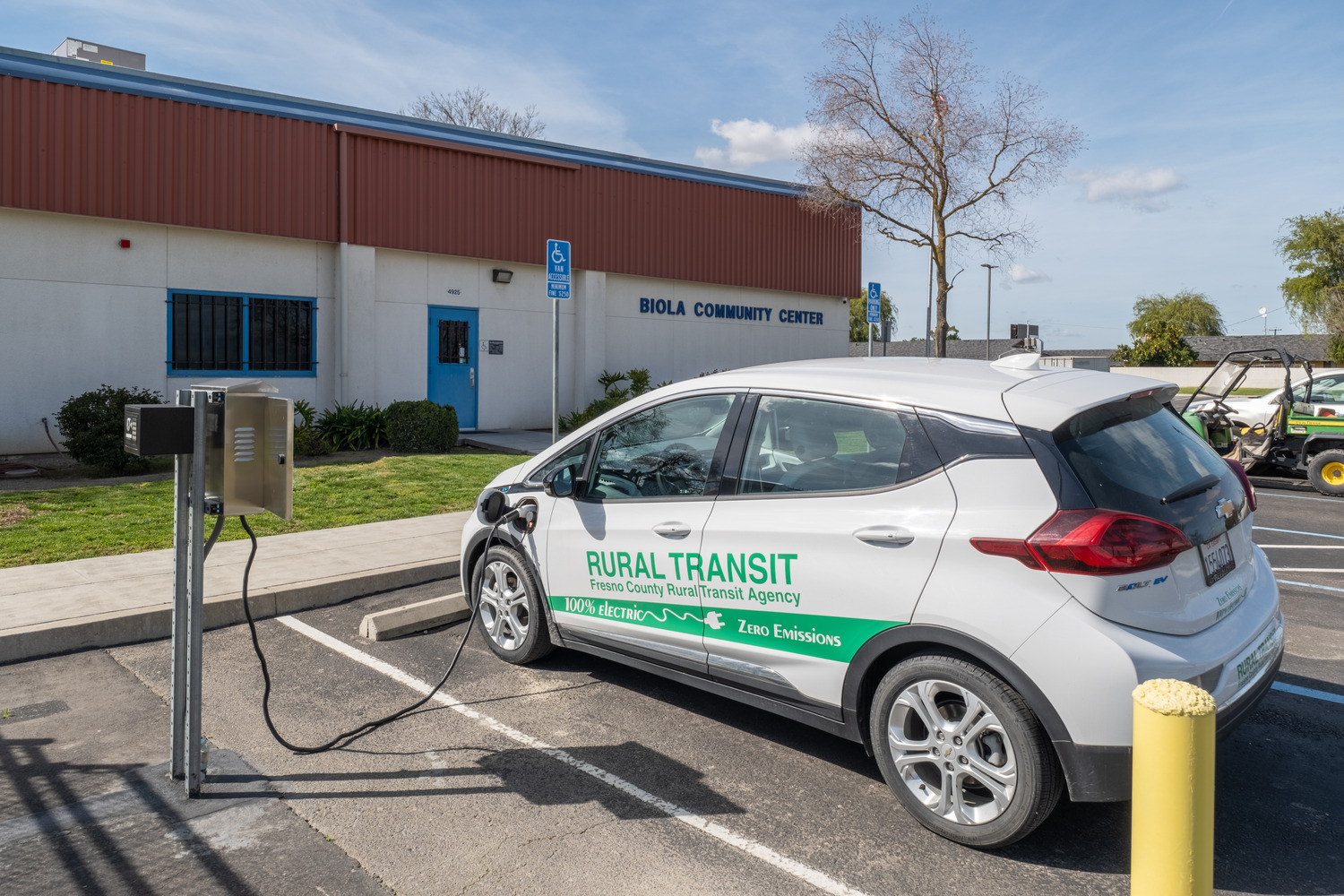 An electric vehicle is plugged in and charging in front of the Biola Community Center